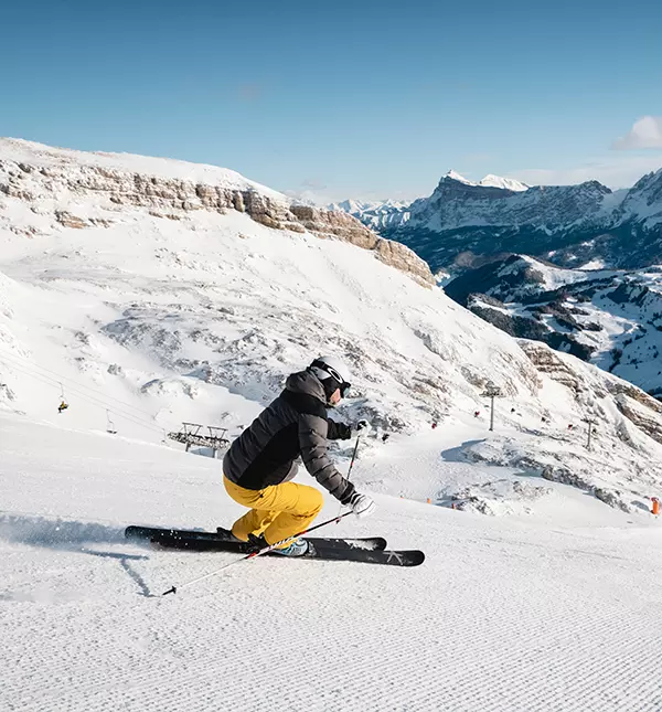 Mann auf Skiern bei der Abfahrt einer der Pisten der Sellarunde>